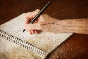 Woman writing poetry in her journal - conceptual image of the creative process