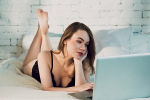 Beautiful young woman in black lace lingerie body lying on the bed