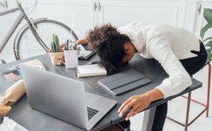 Tired freelancer sleeping on her deak