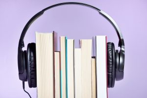 Close-Up Of Books With Headphones Against Purple Background