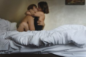 Couple hugging and kissing on bed