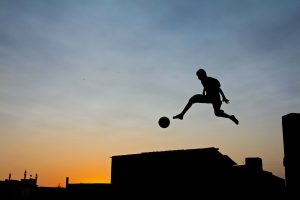 Boy is jumping with soccer ball