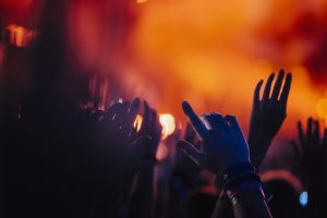 Hands raised, cheering in concert audience