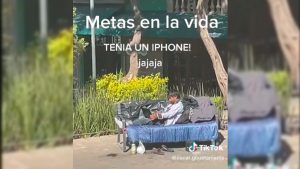 Indigente con iPhone en un parque