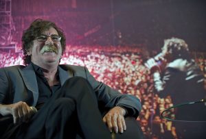 Charly García sonriendo en una rueda de prensa